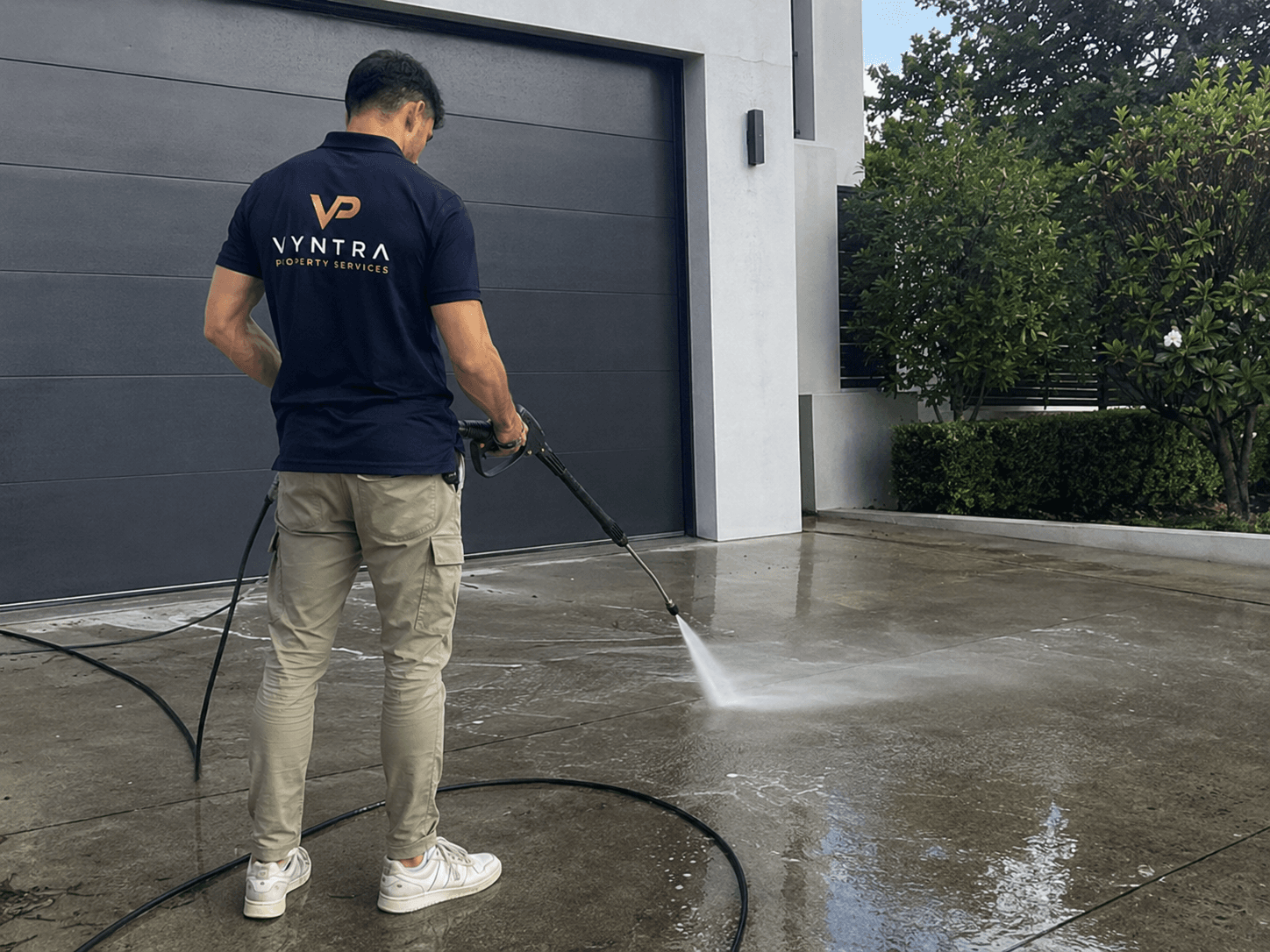 A Vyntra pressure-washing professional restoring a stained driveway to a like-new finish